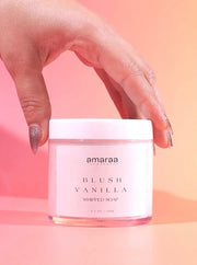 Hand holding Amaraa Blush Vanilla whipped soap jar against a pink background